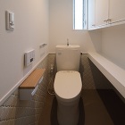 トイレの右手 棚の下はネコ用トイレスペースです<br>床・壁はタイル張り 入り口扉にもネコ用扉を取り付けています<br>ねこさんがお好きな水の流れるタンク付便器です トイレの右手 棚の下はネコ用トイレスペースです<br>床・壁はタイル張り 入り口扉にもネコ用扉を取り付けています<br>ねこさんがお好きな水の流れるタンク付便器です