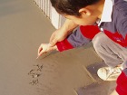 駐車場のコンクリートに名前を書いています