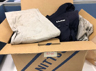 fig: Packing used work clothes into cardboard boxes for shipment fig: Packing used work clothes into cardboard boxes for shipment