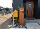 所沢市 K様邸 天然木の門柱と黄色いポス... 門柱 外壁とポスト、門柱、グリーン、全て...