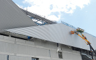 市立吹田サッカースタジアム｜施工例紹介｜... ＜覆い壁＞にはヨドルーフ66を斜め貼りし...