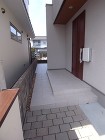 玄関ポーチから奥へと続くタイルテラスが奥...