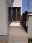 玄関ポーチから奥へと続くタイルテラスが奥...