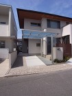 玄関ポーチから奥へと続くタイルテラスが奥...