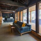 パブリックスペース（手前）　テラス（右）<br />
・新設した８ｍの大開口。南からの直射光を裏庭が受け止め、その反射光が内部を優しく照らす。　内部の壁を黒色塗装で暗部とし、意識が外の裏庭へと誘われるよう配慮している。