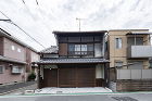 増築されていた店舗を撤去し建設当初の姿に復原。庇や木格子を復活。アルミサッシを木製建具に変更。土壁や板貼を補修。