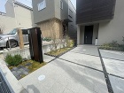 吹田市のガレージリフォーム物件リフォーム前の様子です。玄関ポーチから同じタイルのアプローチが続き左側は植栽スペースと大きめの機能門柱がポイントのなっていました
