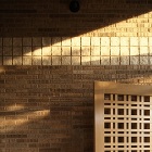 木村哲矢建築計画事務所 | 山陰の住まい アプローチのタイル壁面に斜めに陽が差し込...