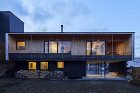 札幌の次世代住宅La Cerisierの外観夜景。片流れ屋根と大きな窓から温かい光が漏れ、周囲の風景と調和した美しいシルエットが浮かび上がる。