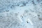 Aerial view of Sogetsu and Shakuzan, two minimalist homes nestled quietly within a dense forest, blending seamlessly with nature