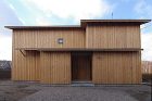 主張を抑え、その場に自然に溶け込む佇まいの家。外壁は板貼りを採用し、押さえ縁を設けることで陰影を生み出し、単調さを避けたデザイン。控えめながらも深みのある外観が特徴。