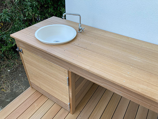 シンク付きカウンターテーブルのあるウッドデッキ