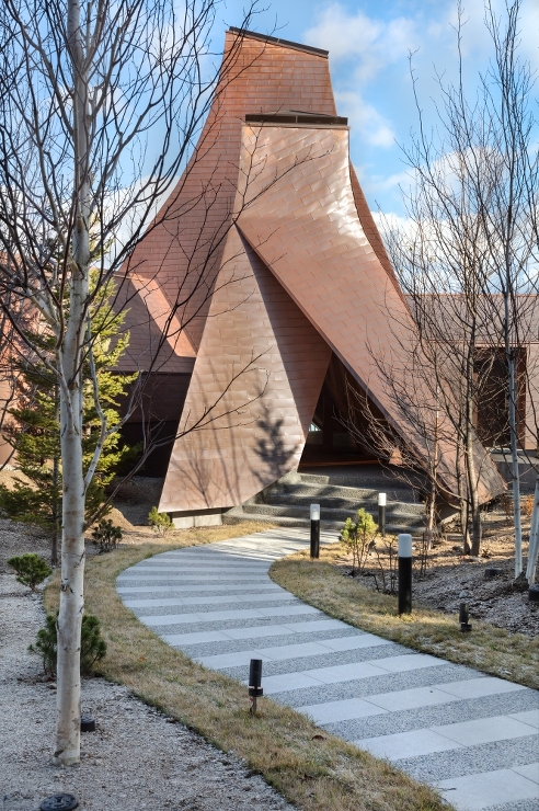 三角錐の建物群のボリューム は景観に配慮し、温泉がでる場所の周辺を最小限に囲むような佇まいとした。©Toshihide Kajihara　 photo