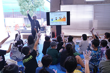 Image: Children energetically raising their hands to answer quiz questions about concrete