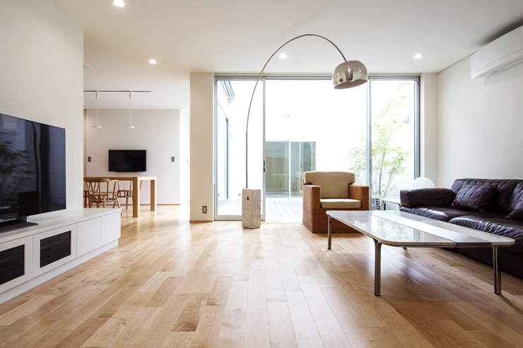 家族と来客を迎える大空間のリビング。中庭のデッキからの光でとても明るい空間です。