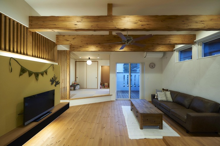 ウッドデッキまでの梁あらわしが印象的な開放的なリビングの画像