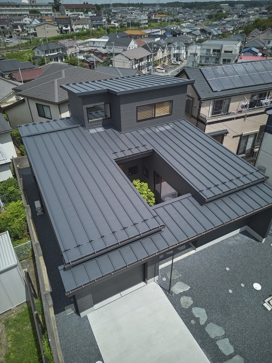 シンボルツリーを囲むガレージのある家の画像