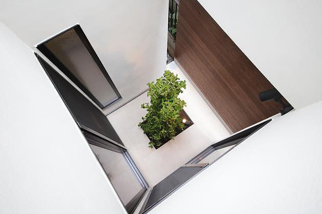 リビングとキッチンに面した明るい白い坪庭、1階は板塀2階は外壁で囲まれプライバシーが保たれている