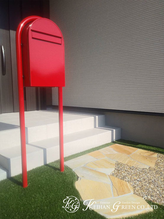 ポストの赤と人工芝の緑がアクセントのナチュラル外構　彦根市