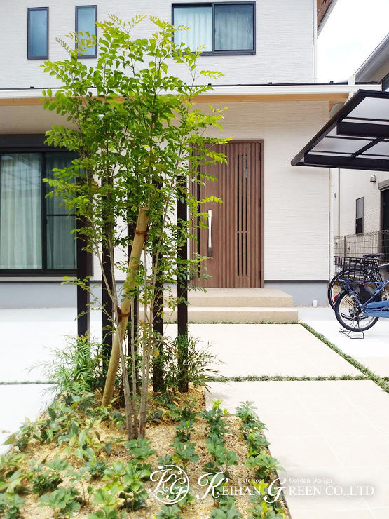 オフホワイトの門柱に植栽の緑が映えるシンプルナチュラル外構　京都市