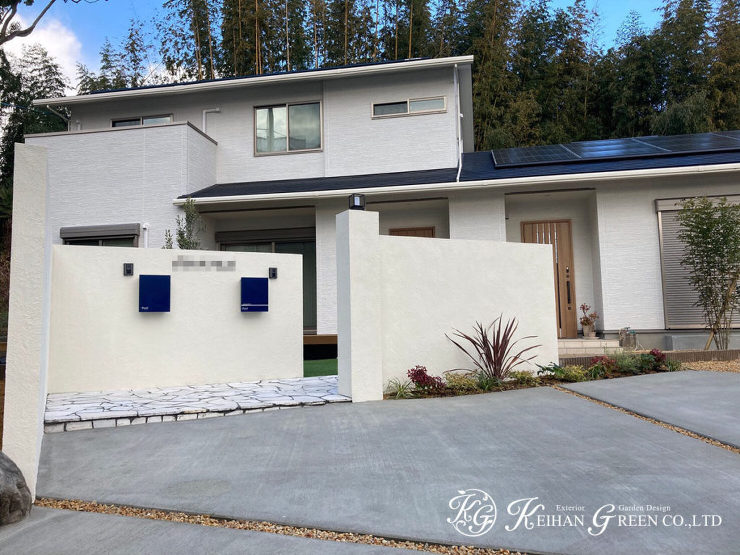 白い塗り壁に表札とポストがアクセントになったシンプルモダンなファサード　大山崎町