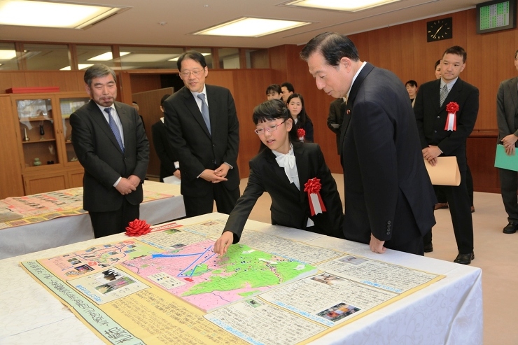 写真：太田国土交通大臣に作品の説明をする柴田さん