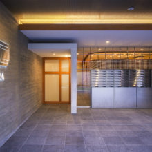 エントランス<br />
杉板型枠打放しの外壁、ステンレス、木製自動ドアで、シンプルに構成。