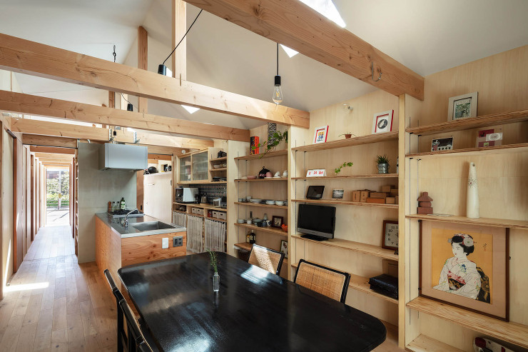 シンプルな木架構は登り梁形式を避けてコストを圧縮。建具は枠を回さず、梁に直接留めた鋼材をガイドレールとして使用。