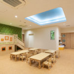 自然をモチーフとした窓のない保育園のホール・遊戯室の写真