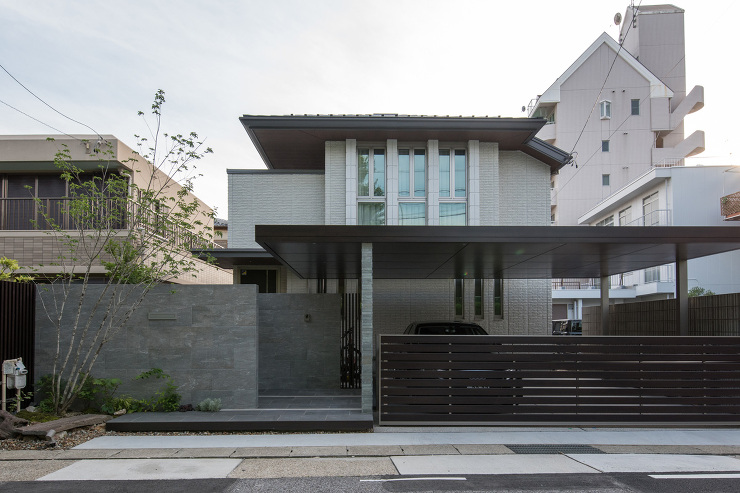 建物の庇とプラスGカールーフ(LIXIL-クリエダーク)が一体感を生み出しています。<br />
大判タイル貼りの門袖壁の高さ、階段のステップに使用したデザイナーズパーツ、植栽、<br />
全て要素を駆使してデザインを構成しています。