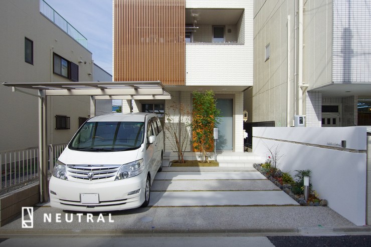 狭小地の駐車場デザインを工夫し、外構全体の広がり感を演出しています。<br />
洗出し仕上げ、金コテ仕上げで道路と平行のラインを生み出しています。<br />
また、隣地との境界に壁を設置する事で空間を独立させています。