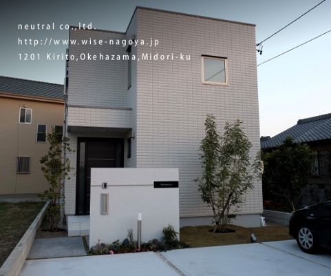 スクエアの建物に絶妙の位置、大きさの門柱を配置。デザインもシンプルに建物との調和を重視。<br />
シマトネリコの影が建物に映る。