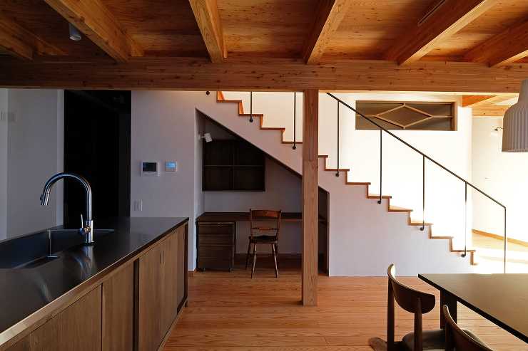 カラマツ集成材の2階床梁の渡りアゴ掛け組みと大黒柱と階段下のニッチのワークスペース