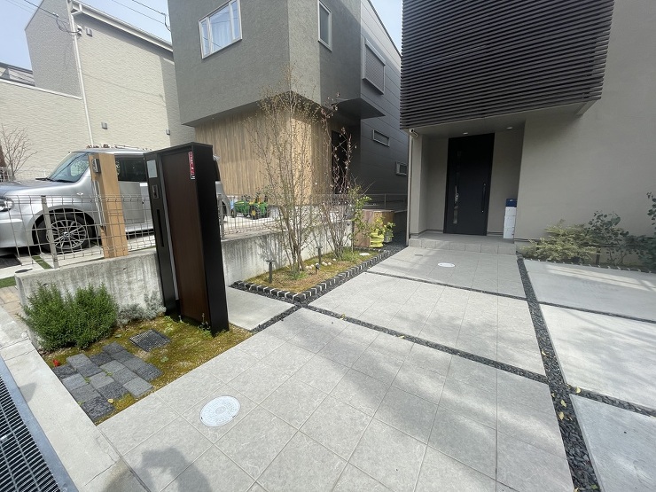 吹田市のガレージリフォーム物件リフォーム前の様子です。玄関ポーチから同じタイルのアプローチが続き左側は植栽スペースと大きめの機能門柱がポイントのなっていました