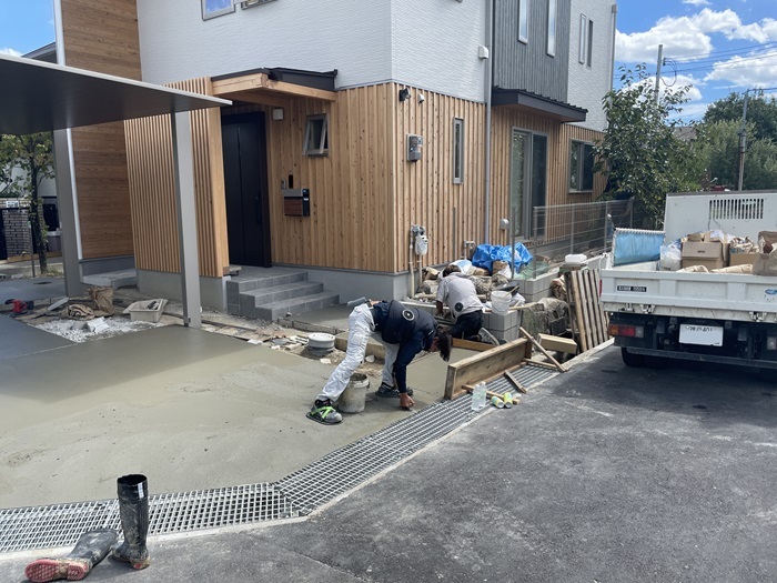 ガレージを左官の職人が施工している様子です。勾配もあり建物とのつながりも意識しながら工事の手を進めています