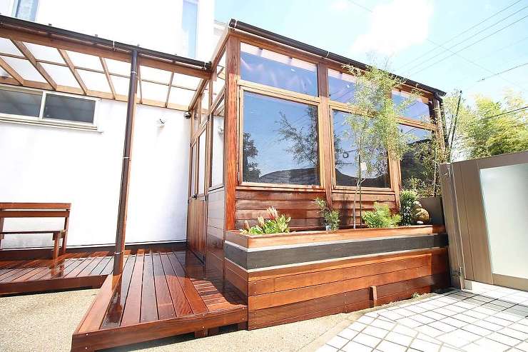 ガーデンルームで庭にくつろぎの空間を取り入れた事例。木製の特注ガーデンルームで庭と一体化できます。