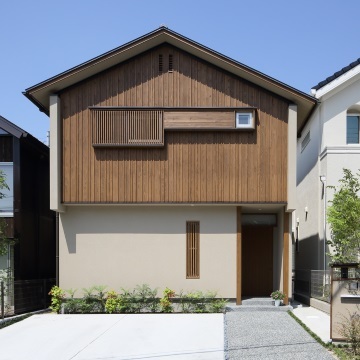 板張りの外観　ランダムな押縁と木製の換気口に格子の出窓がアクセントを添えます