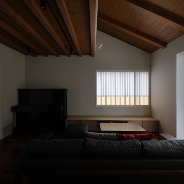 居間の天井は2階を支える水平の梁と勾配屋根の上り梁が直交して現れています