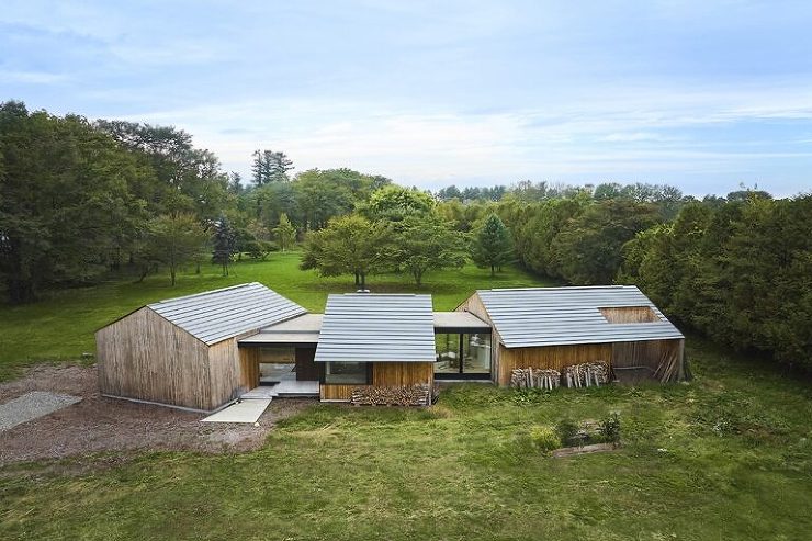 サンの家」のアプローチ側外観写真。建物と周囲の配置計画により、3本のシンボルツリーと緑豊かな庭が常に視界に入る設計が特徴的。自然と調和した空間デザインが訪れる人を迎え、心地よいアプローチを演出。