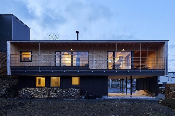 札幌の次世代住宅La Cerisierの外観夜景。片流れ屋根と大きな窓から温かい光が漏れ、周囲の風景と調和した美しいシルエットが浮かび上がる。