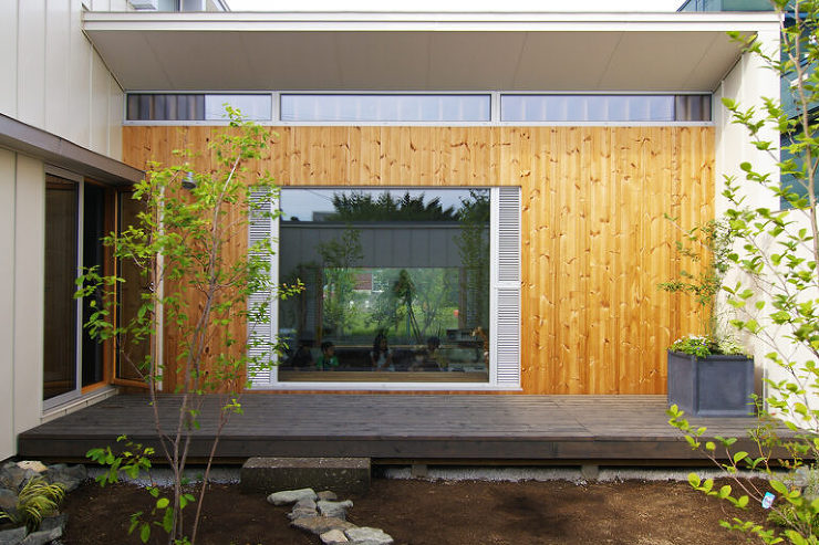 Beatの中庭からの外観写真。ステージに見立てた通路と、客席に見立てた1段下がったリビングが配置され、両側に設けられた窓が空間に広がりを与えています。