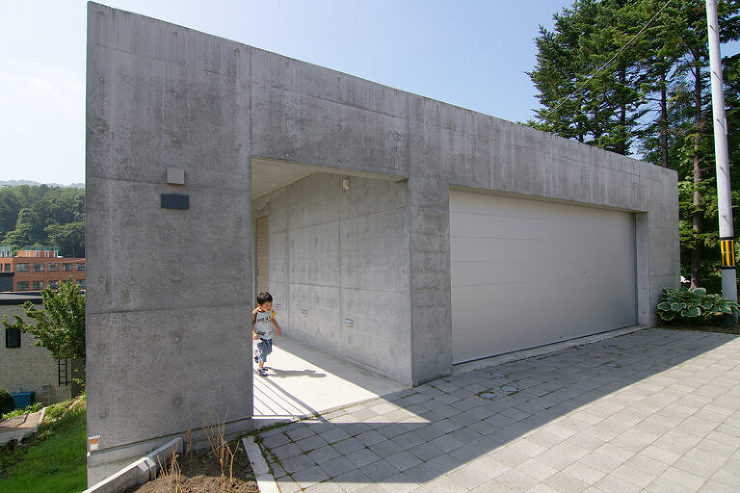 BRIDGE HOUSEの外観。下に傾斜した敷地に沿って、長い橋を渡るようなイメージで玄関へアプローチ。期待感を高める装置として、空間の魅力を引き出しています。