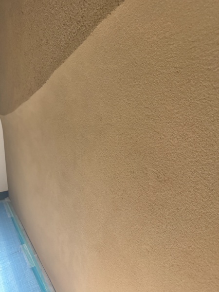 山のような立体感のあるラインを入れて目の粗さも違いを出したプラスタル搔き落としで施工したエントランス壁面。下側が目の細かい掻き落とし