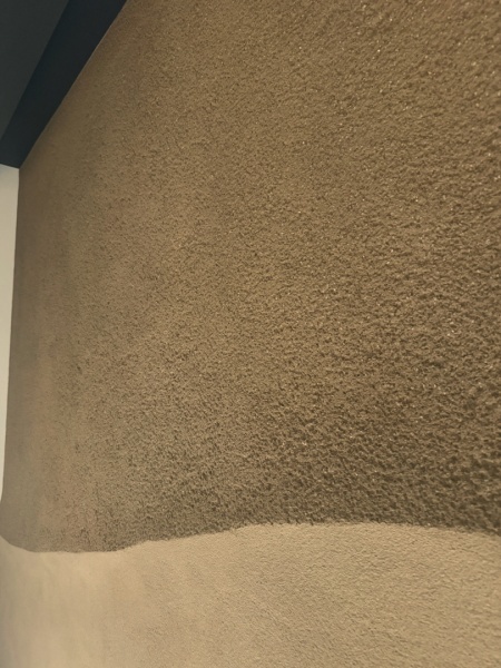 山のような立体感のあるラインを入れて目の粗さも違いを出したプラスタル搔き落としで施工したエントランス壁面。上側が目の粗い掻き落とし