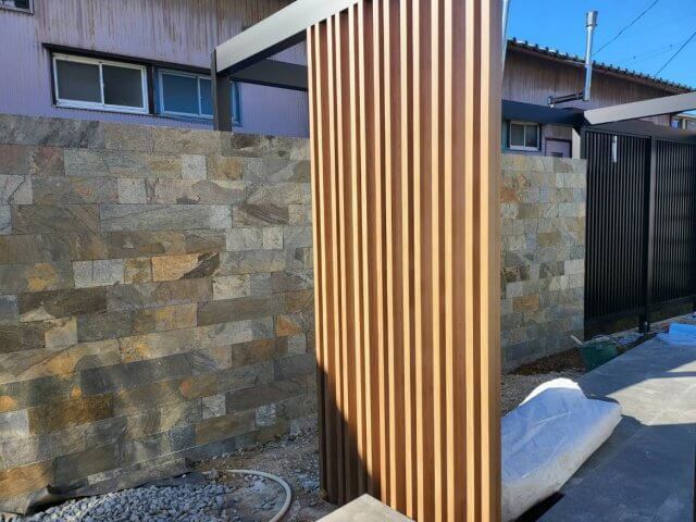 自然石貼りの壁と、ウッドデッキ×タイルテラスの組み合わせのお庭 施工風...