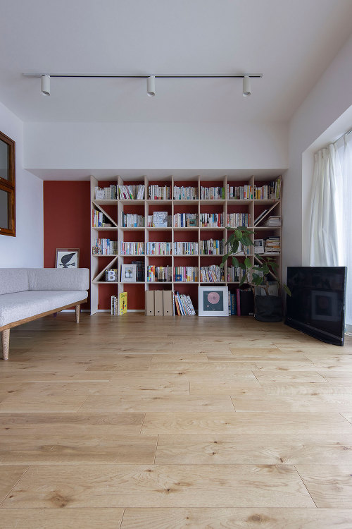 赤いアクセントウォールを背景に ? Shelf 壁一面の本棚 奥行25...